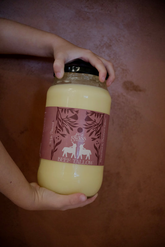 Hand holding Glass Wholefoods Beef Tallow 1L glass jar with pink label showing grass-fed and finished Australian tallow