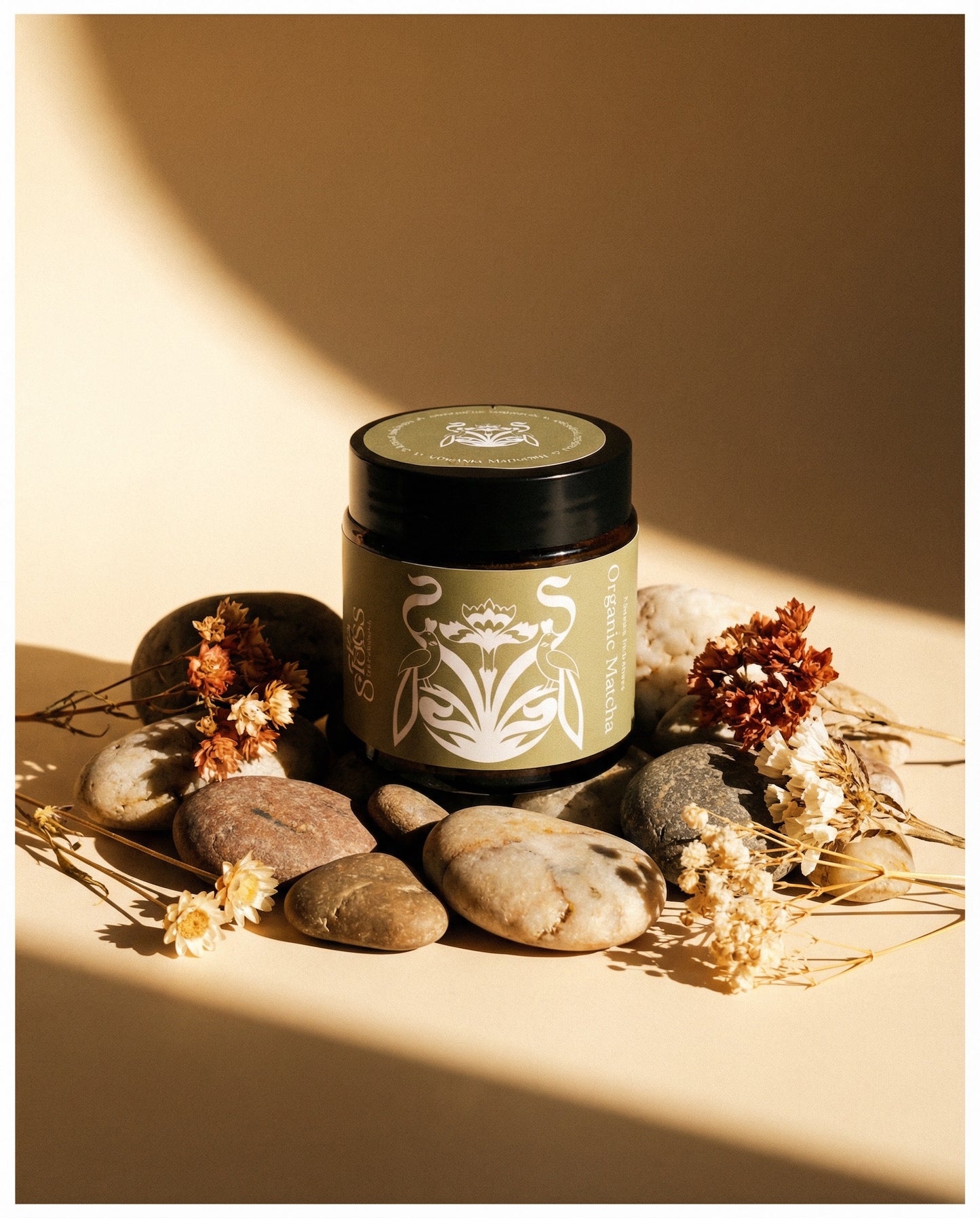 Glass Wholefoods Organic Ceremonial Matcha jar styled with natural stones and dried flowers