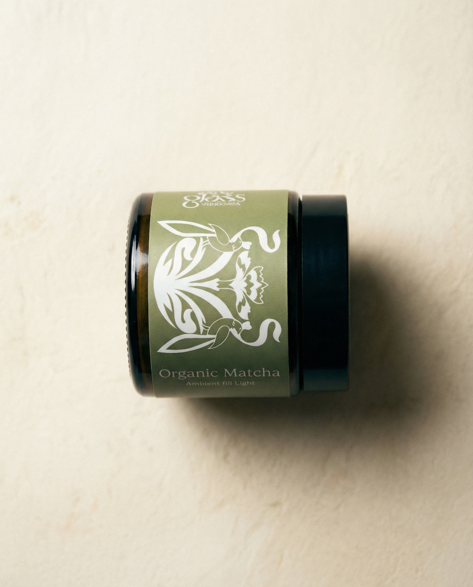 Glass Wholefoods Organic Ceremonial Matcha 50G in a dark glass jar with botanical design
